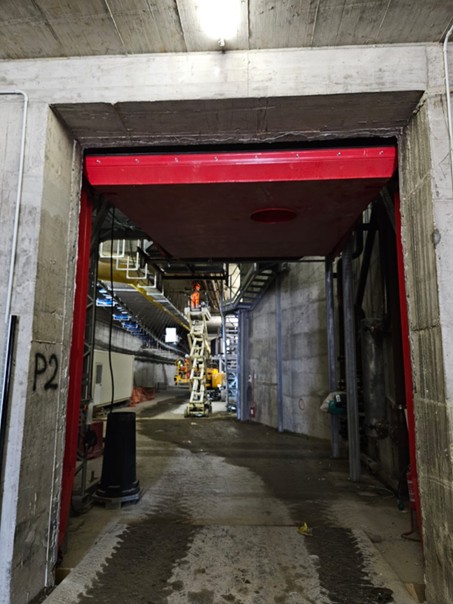 Heavy-duty red steel sectional door for tunnel boring hyperbaric chamber access